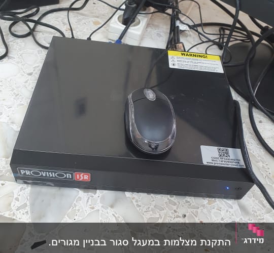מכשיר הקלטה של מצלמות אבטחה עם עכבר על גבי